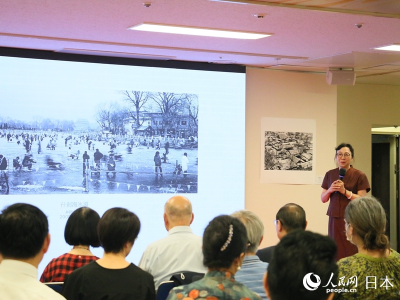拍攝者介紹展出作品。人民網 許可攝