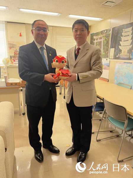 中國駐東京旅游辦事處主任歐陽安（右）向山形縣政府贈送“吉祥蛇”。中國駐東京旅游辦事處供圖