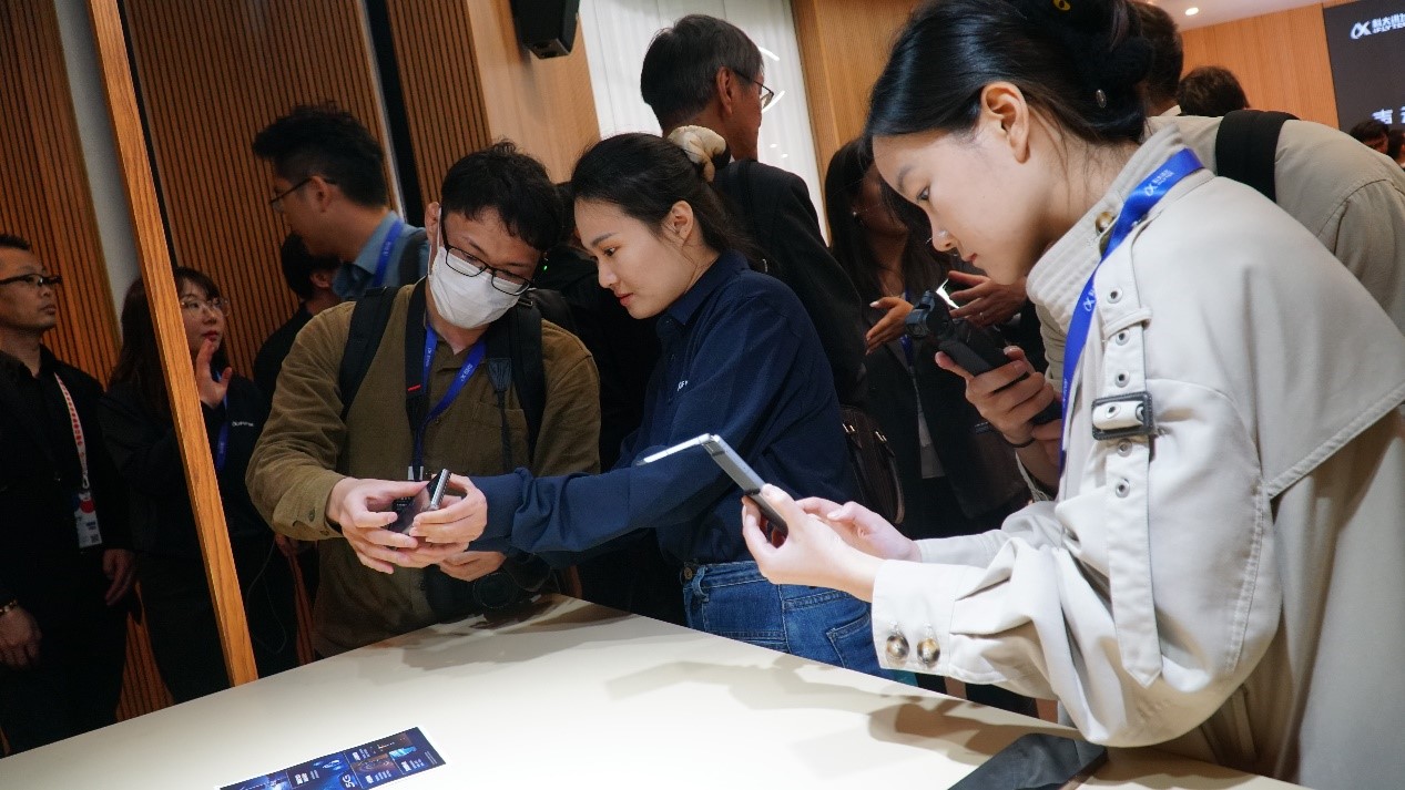 發布會上，與會嘉賓試用訊飛雙屏翻譯機2.0。人民網 蔣曉辰攝