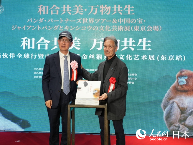薛康（左）與土居利光（右）為《中國雙寶：享譽世界的大熊貓和金絲猴》攝影畫冊發布揭幕。人民網 許可攝