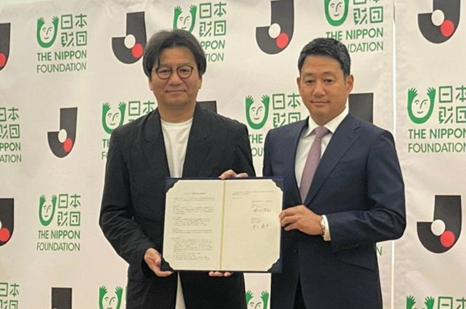 [配圖說明：出席合作協定簽訂儀式的日本職業足球聯賽主席野野村芳和（左）與日本財團的笹川順平專務理事]