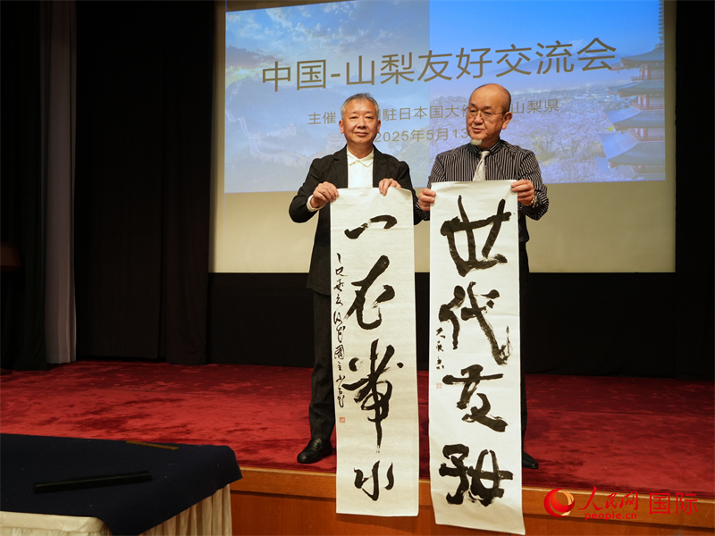 兩國書法家共同書寫“一衣帶水、世代友好”。人民網 許可攝