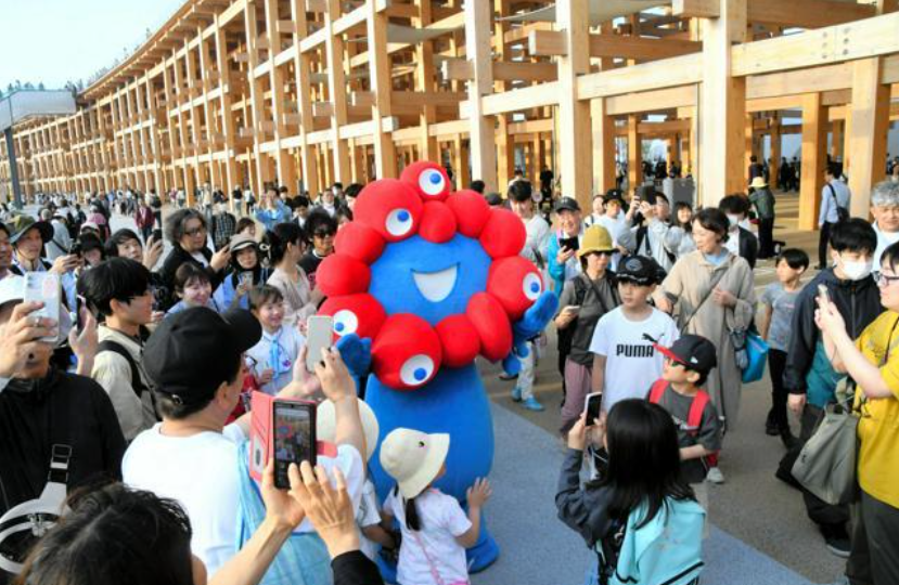 圖片：大阪世博會的官方吉祥物“脈脈”(MYAKU-MYAKU)“脈脈”吸引了大量觀眾圍觀。（圖片來源：《朝日新聞》）