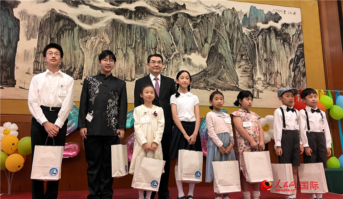 吳江浩大使向第十一屆“大使杯”中文朗誦比賽獲獎選手贈送節日禮物。人民網 許可攝