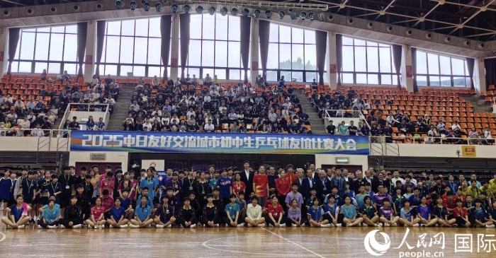出席2025中日友好交流城市初中生乒乓球友誼比賽大會開幕式的嘉賓與參賽選手等合影留念。人民網記者 陳建軍攝