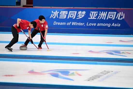 2月13日，日本隊選手邊見涉（右）和渡邊陽紀在比賽中擦冰。新華社記者 黃博涵 攝